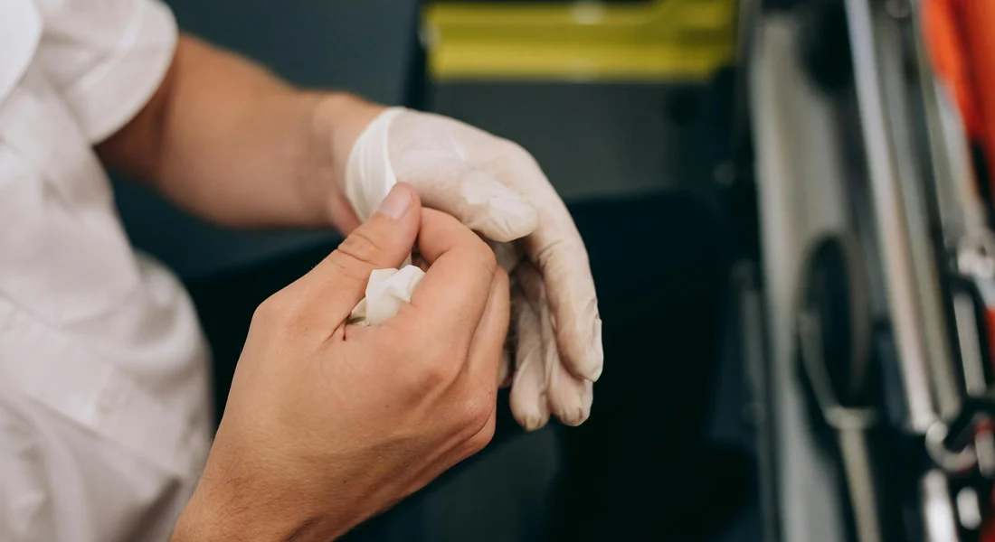Close-up of gloved hands applying a bandage to a horse's leg