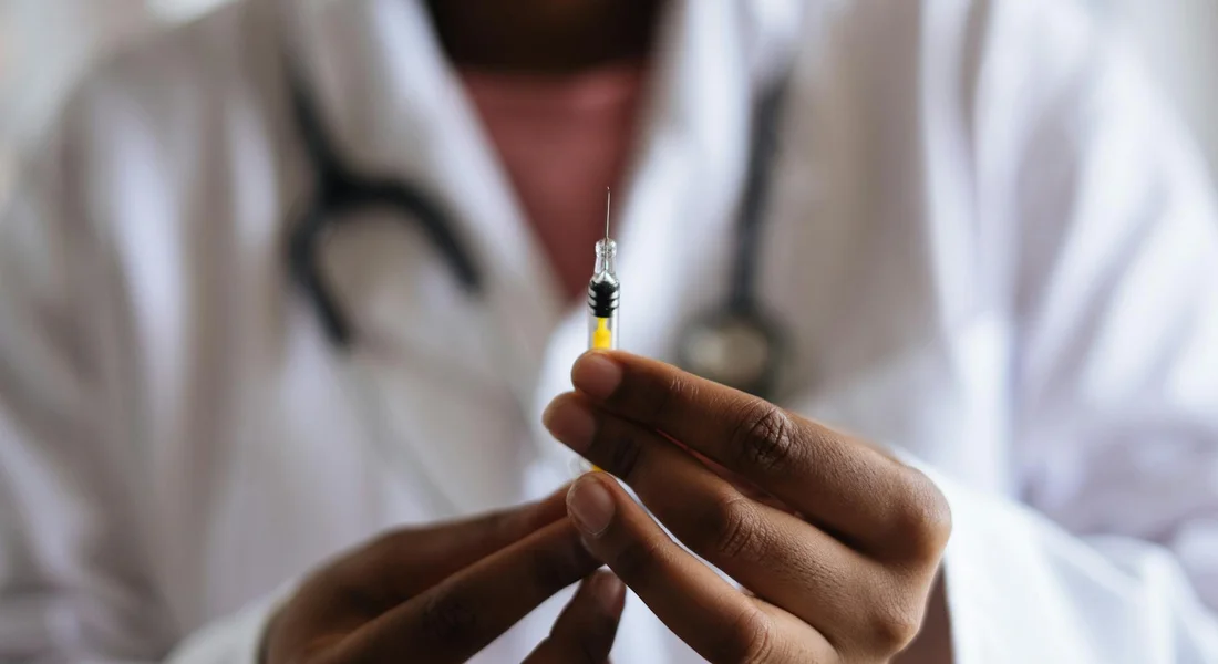 Close-up of a veterinarian's hands holding a syringe, preparing a horse vaccination.