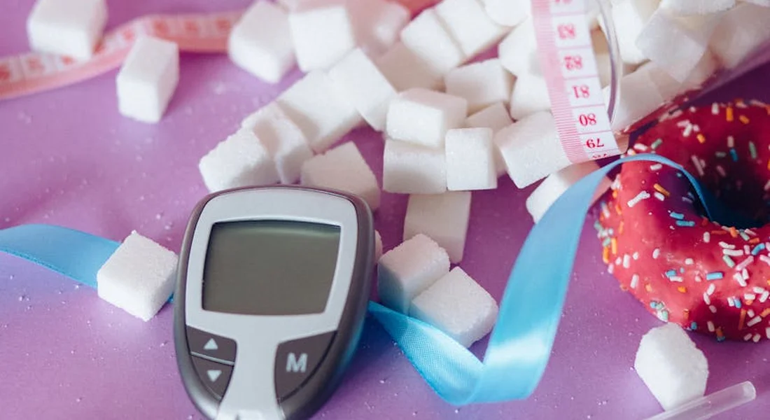 Close-up of white sugar cubes, a measuring tape, and a blue ribbon on a pink surface, suggesting DIY horse treat preparation.